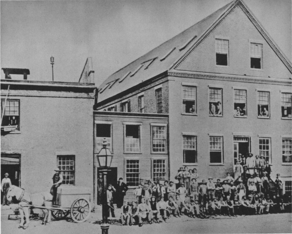 Early photograph of the Nashua Lock Company plant and its employees in Nashua, New Hampshire.